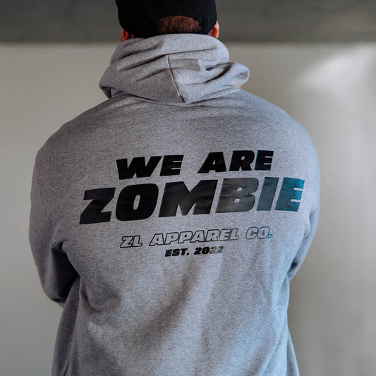 Man wearing a grey Zombie Labs hoodie with 'We Are Zombie' text on the back, standing with his back to the camera.